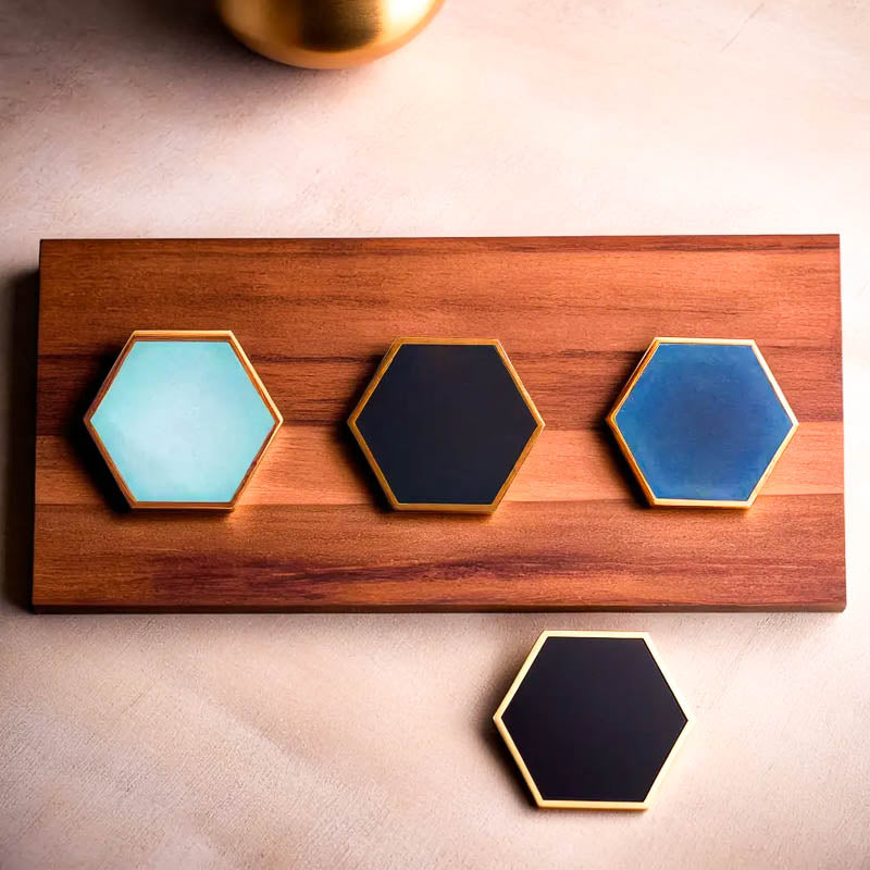 Sottobicchieri esagonali in ceramica di Audacem in vari colori su una tavola di legno