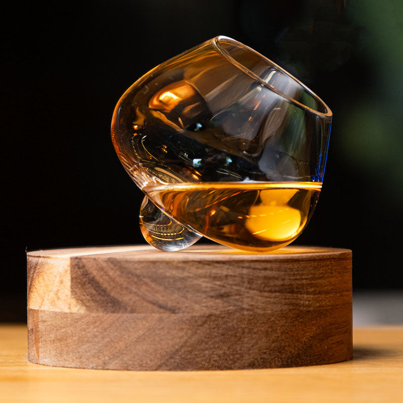 Bicchiere da distillato in cristallo Aequilibrium di Audacem su sottobicchiere artigianale in legno per whisky, liquori e distillati