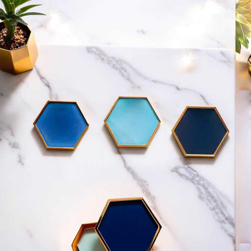 Set di sottobicchieri esagonali in ceramica di Audacem su una superficie di marmo