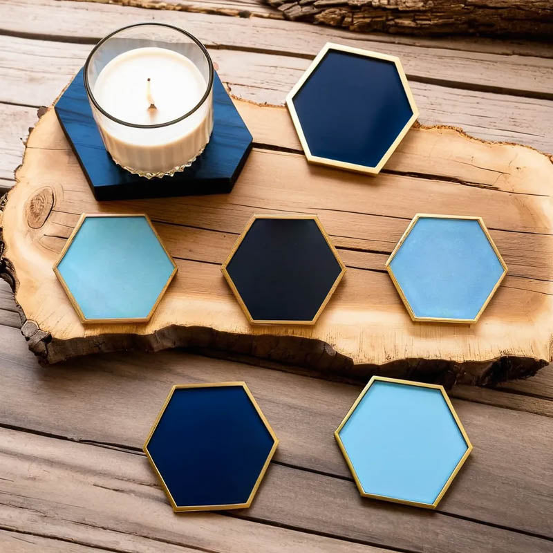 Sottobicchieri esagonali in ceramica di Audacem con una candela su una tavola di legno